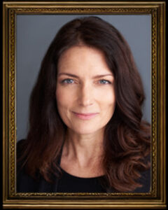 Portrait of a confident woman with long brown hair and blue eyes.