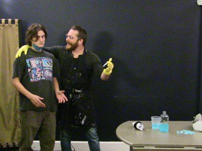 Two men interacting, one holding a banana.