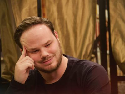Thoughtful smiling man resting head on hand