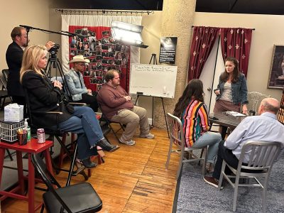 A group discussion in a cozy room with a whiteboard and curtains.